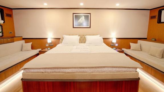 Spacious gulet bedroom. You can see a large bed and two additional sofas